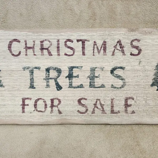 Hand-painted sign advertising Christmas trees for sale.