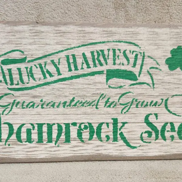 Vintage-style sign for Shamrock Seeds, promoting a lucky harvest and guaranteed to grow.