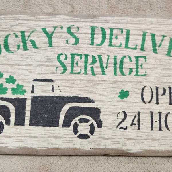 Vintage-style sign for Rocky's Delivery Service with a truck and 24-hour service text.