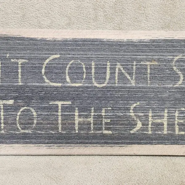 A rustic sign that reads 'It counts so to the sheep'.