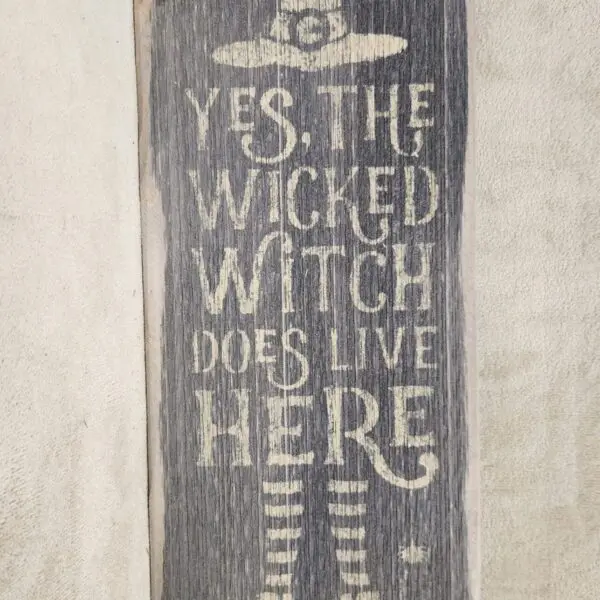 Rustic sign declaring "Yes, the Wicked Witch does live here."