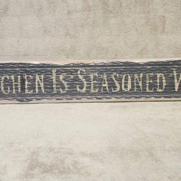 A rustic wooden sign reads 'Kitchen is seasoned with love.'
