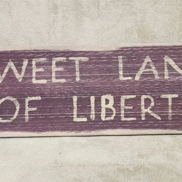 A textile piece with the phrase 'SWEET LAND OF LIBERTY'.