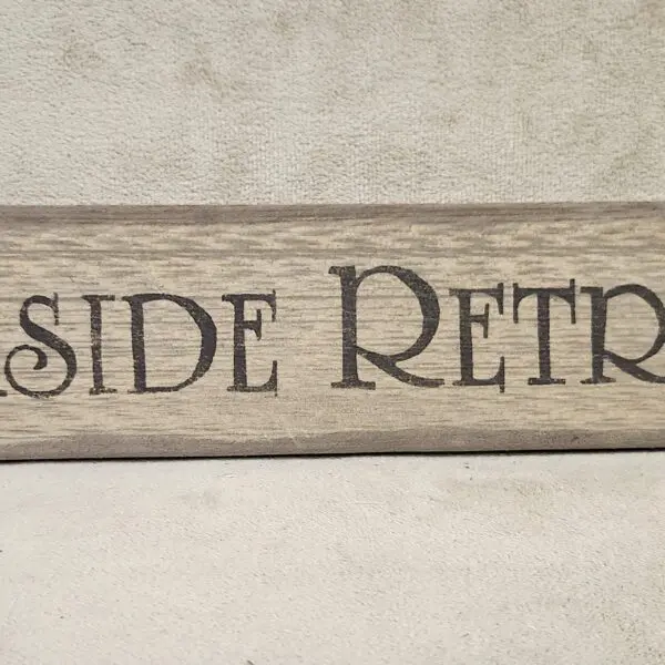 Wooden sign with 'SIDE RETRO' engraved in a rustic style.