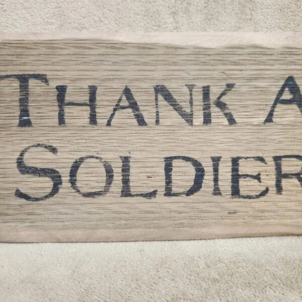 Wooden sign with 'Thank a Soldier' engraved in bold letters.