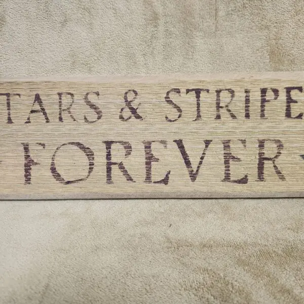 A close-up of text reading 'STARS & STRIPES FOREVER' on a textured surface.