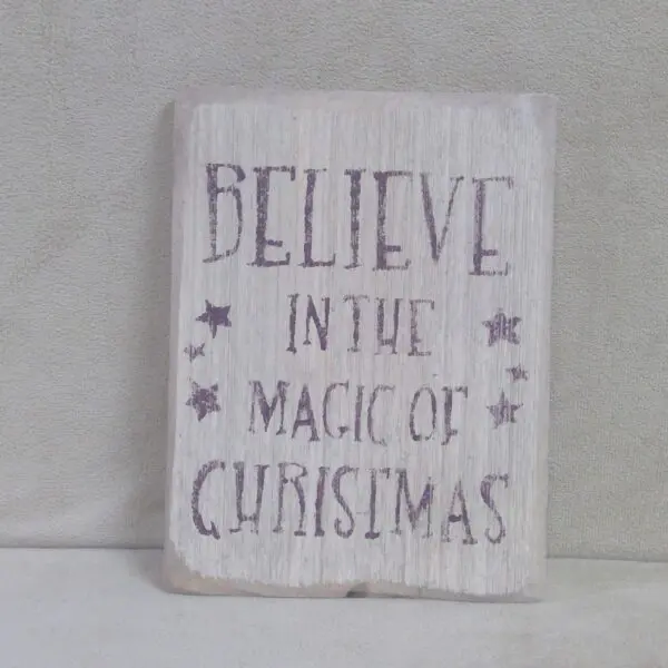 A festive sign saying 'Believe in the Magic of Christmas' with stars.