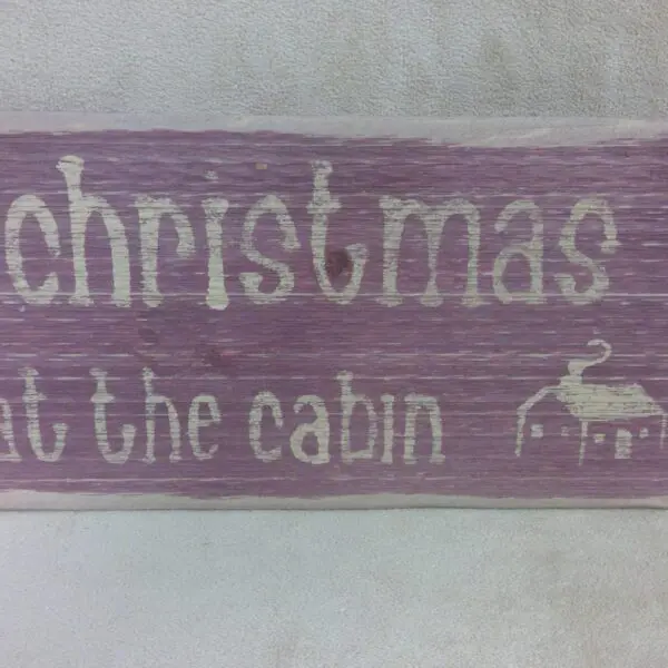 A rustic wooden sign with a Christmas theme and a reindeer illustration.