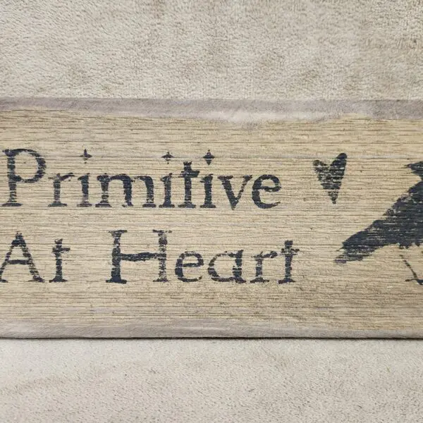 Rustic wooden sign with text and a bird silhouette.