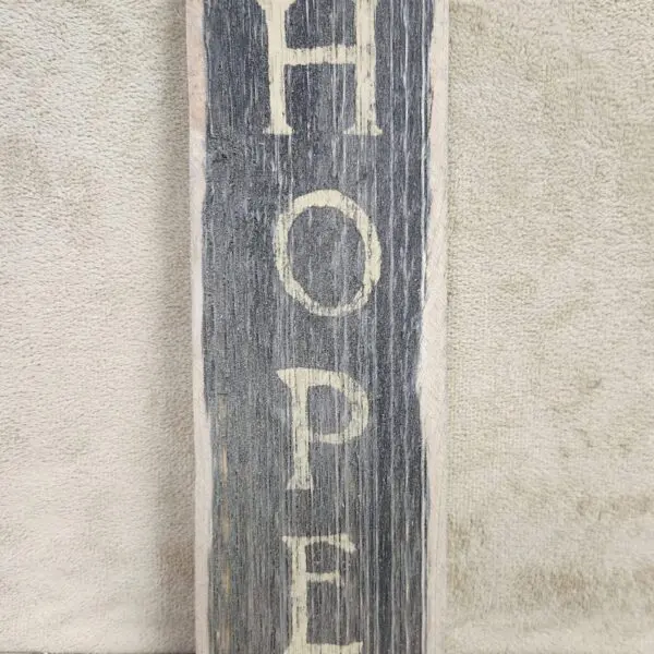 A rustic wooden sign with the word 'HOPE'.