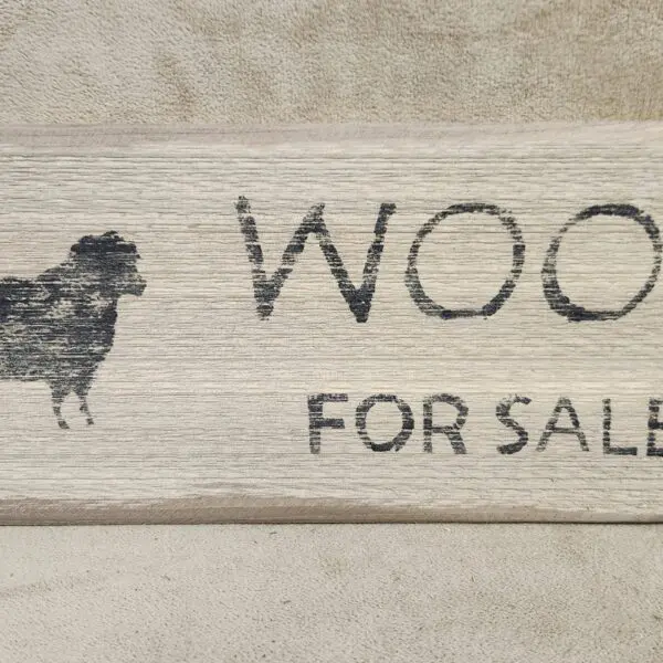 Rustic wooden sign with a sheep illustration and 'Wool For Sale' text.