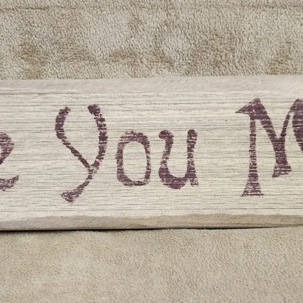 A wooden sign with the text 'Love You Mom'.