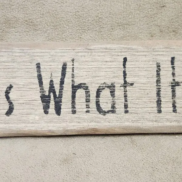 A wooden sign reads 'This is what it is.'