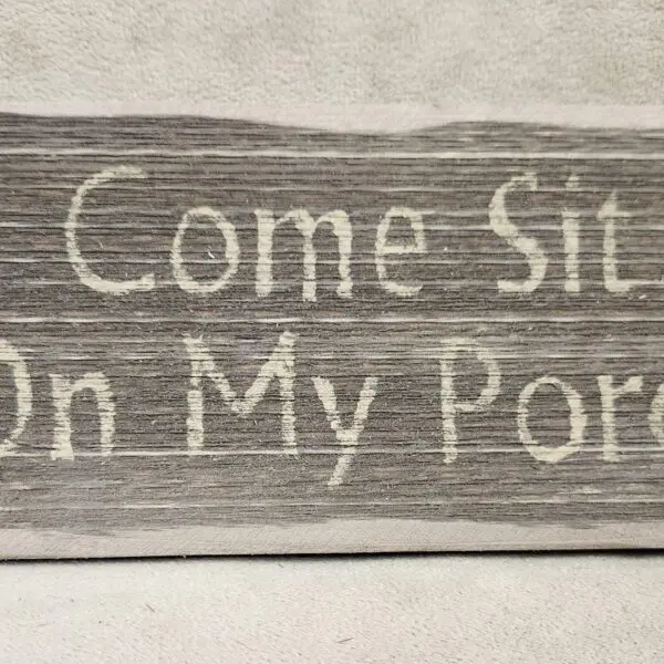 Rustic wooden sign saying 'Come Sit On My Porch'.