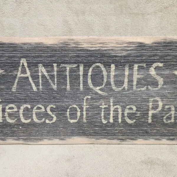 Rustic wooden sign reading 'ANTIQUES Pieces of the Past'.