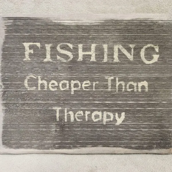 A rustic sign that reads "FISHING Cheaper Than Therapy."