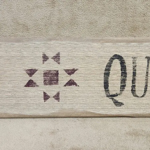 A wooden sign with a star-like design and partial text.