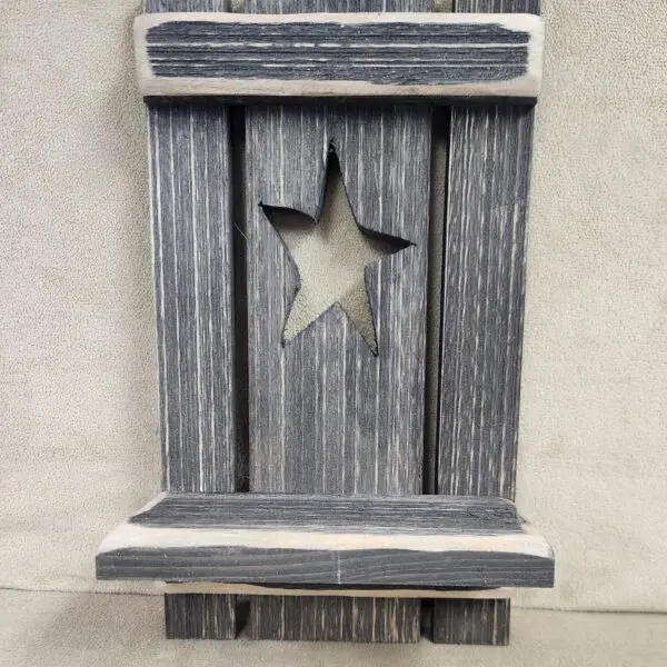 Rustic wooden wall decoration with a star cutout.