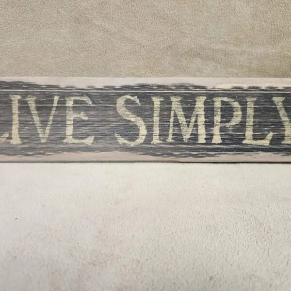 Wooden sign that says 'Live Simply'.